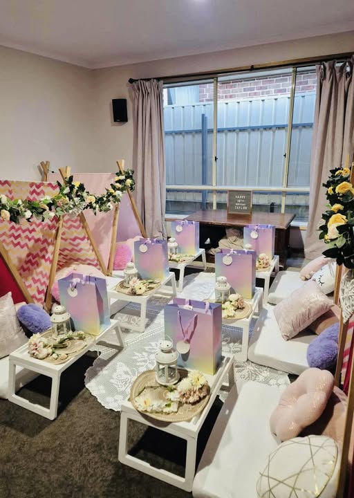 Pink and purple styled teepee party room with gift bags and tray tables