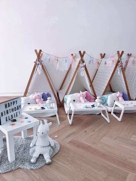 White and pastel teepees with unicorn cushions and a birthday lightbox
