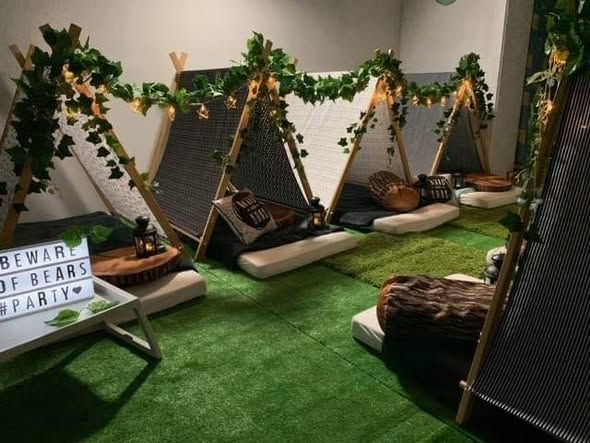 Jungle themed teepees with greenery, fairy lights and grass mats